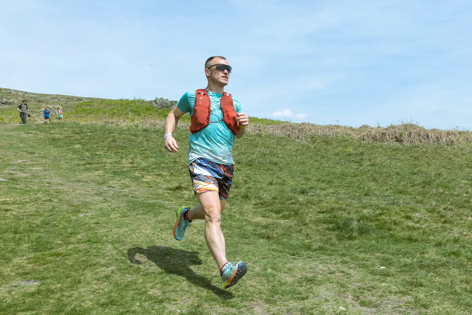 A runner on the trails with Old John tower behind, at a RunThrough Coach trail running workshop